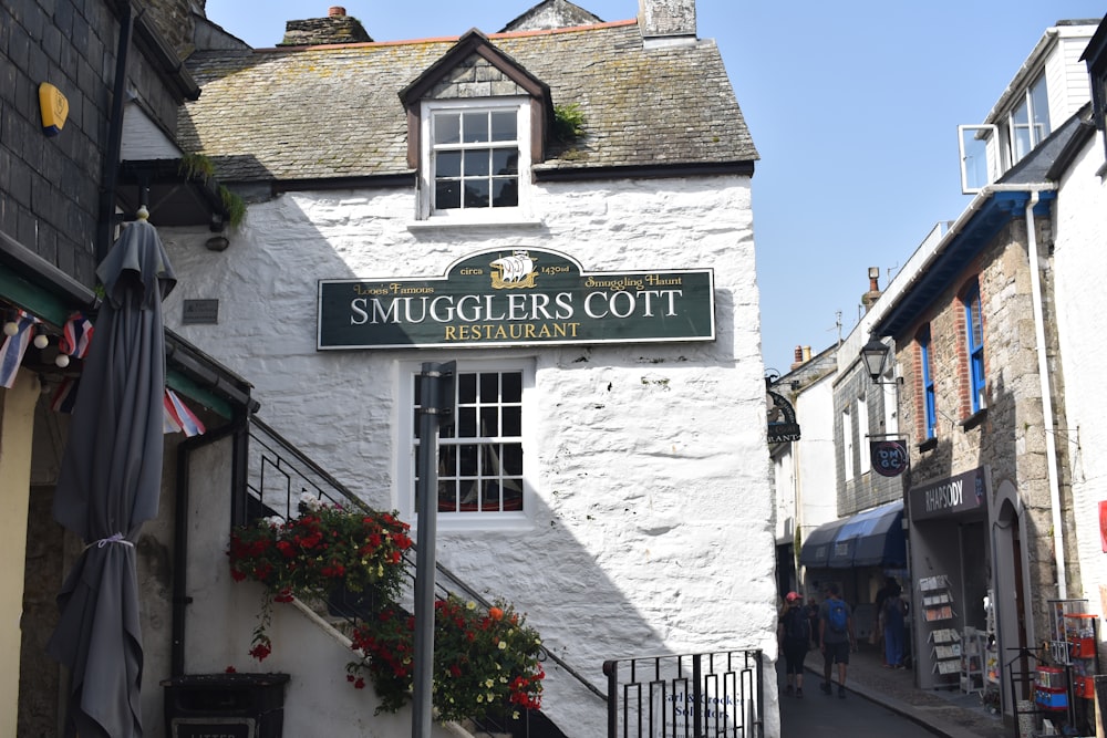 a white building with a sign that says smuggers cottage