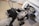 The image features a close-up of a classic motorcycle with a black and white color scheme. The front view highlights the handlebars, headlight, and part of the engine. A sidecar is attached to the motorcycle, with a black seat and a chrome rearview mirror visible.