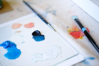 a close up of paint and a brush on a piece of paper