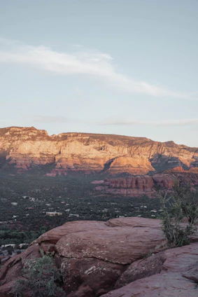 A serene southwestern landscape with soft sandstone cliffs and sage green plants under a muted blue sky, evoking calm and balance.