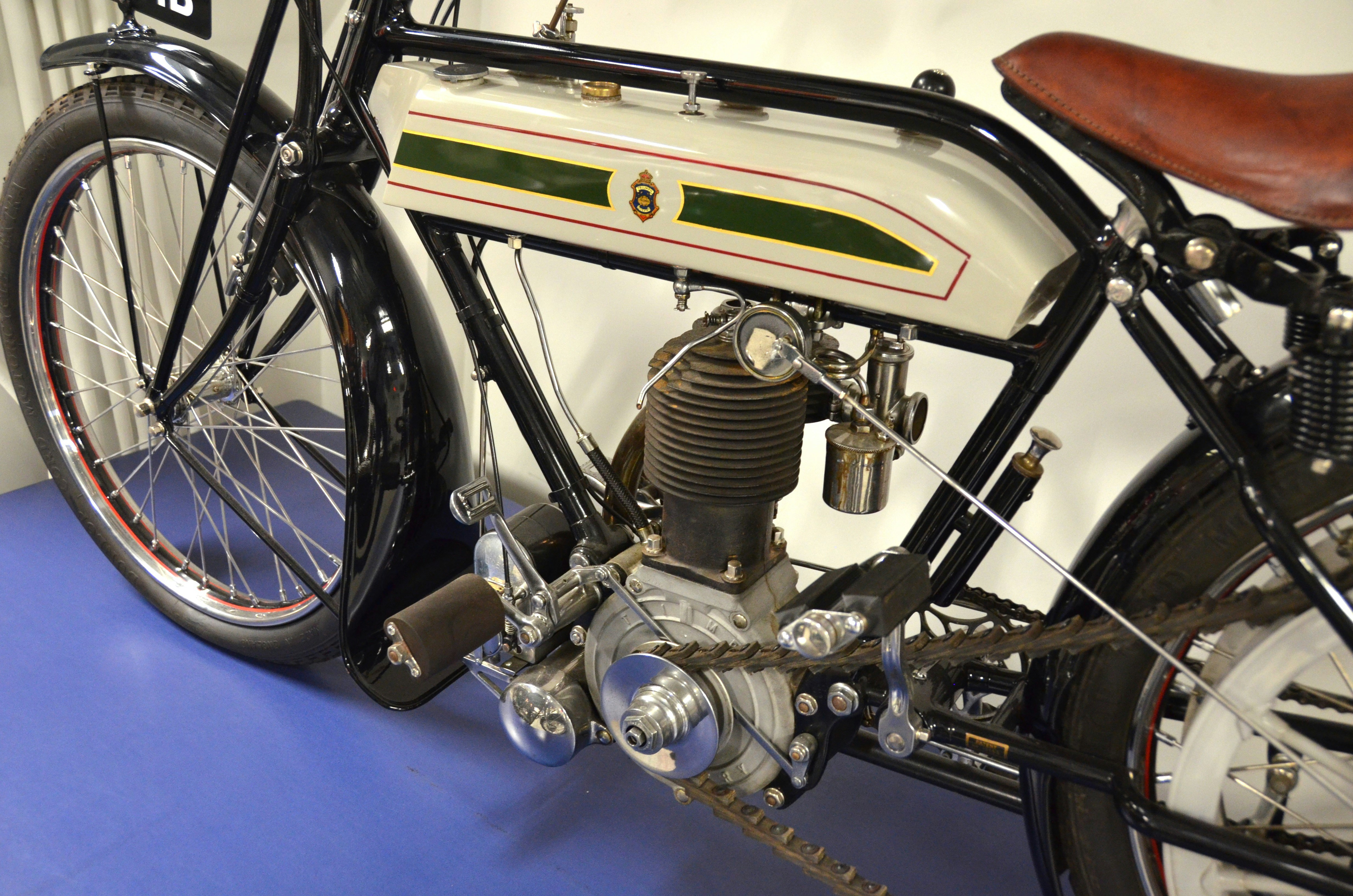 Vintage motorcycle detail shot showing worn leather seat, patina chrome, and weathered paint telling stories