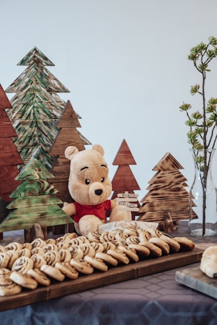 a teddy bear sitting at a table with cookies