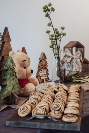 A cozy arrangement of soft plush toys and wrapped chocolates on a wooden table