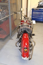 A vintage motorcycle parked in a cozy garage filled with tools and memorabilia.