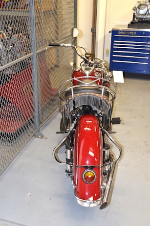 A vintage motorcycle parked in a cozy garage filled with tools and memorabilia.