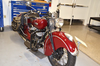 Vintage motorcycle with fresh paint and polished chrome parked in the workshop.