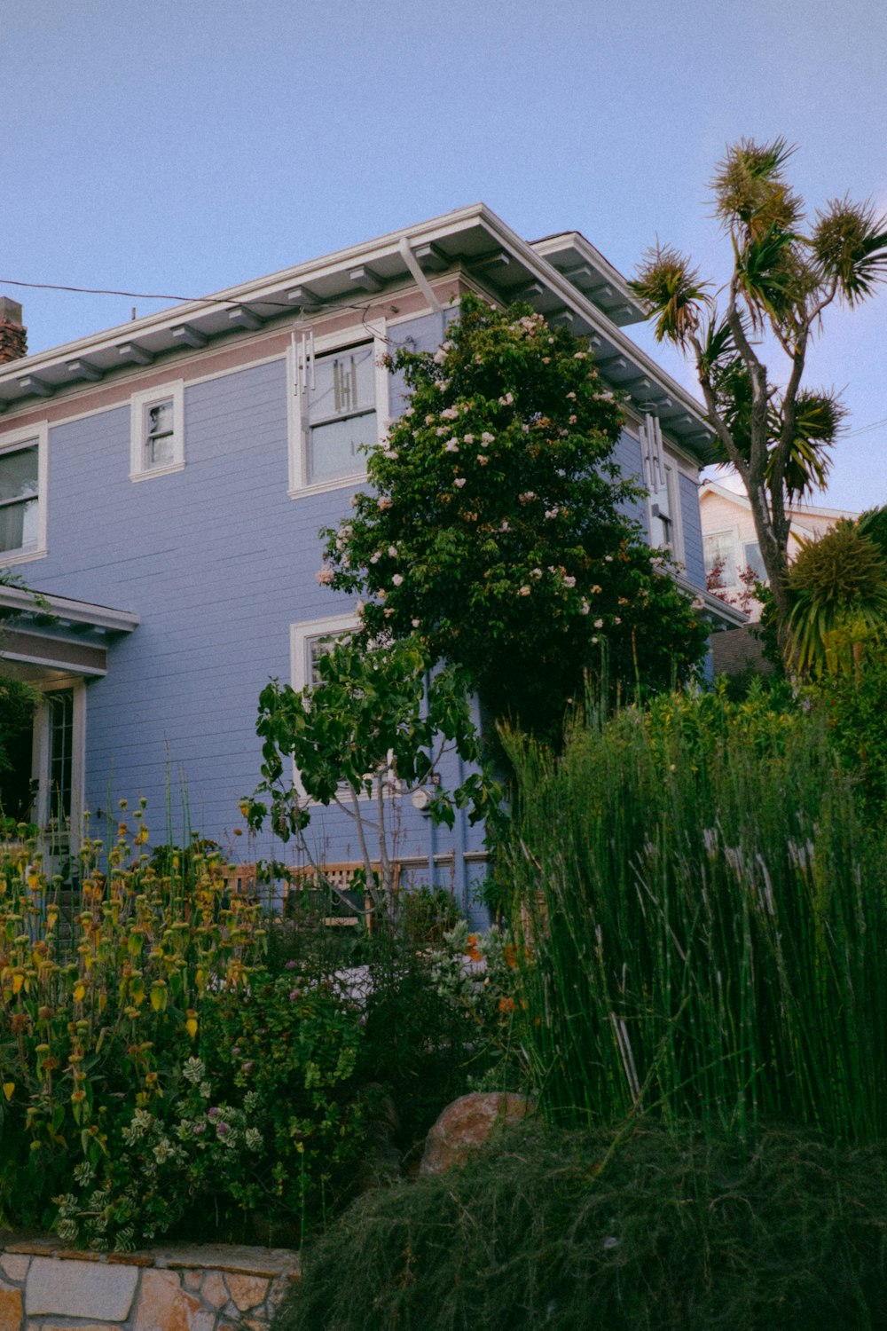 a blue house with a clock on the front of it