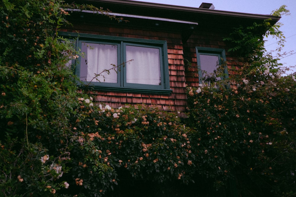 Una casa de ladrillo rojo con una ventana verde