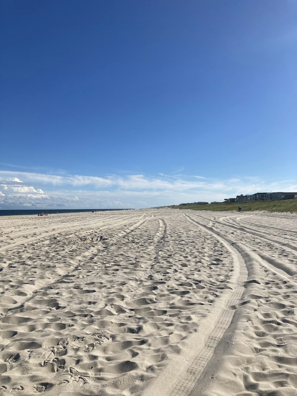 a sandy beach with tracks in the sand