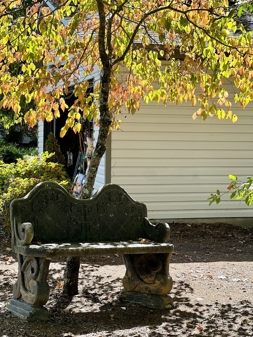 a stone bench in front of a house