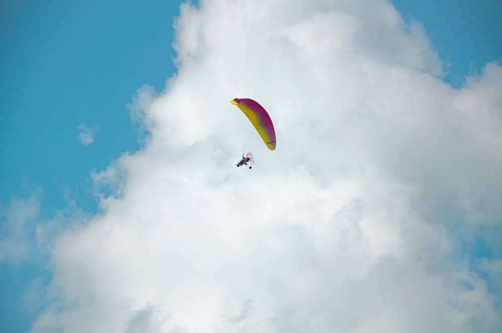 a person is parasailing in the sky on a cloudy day