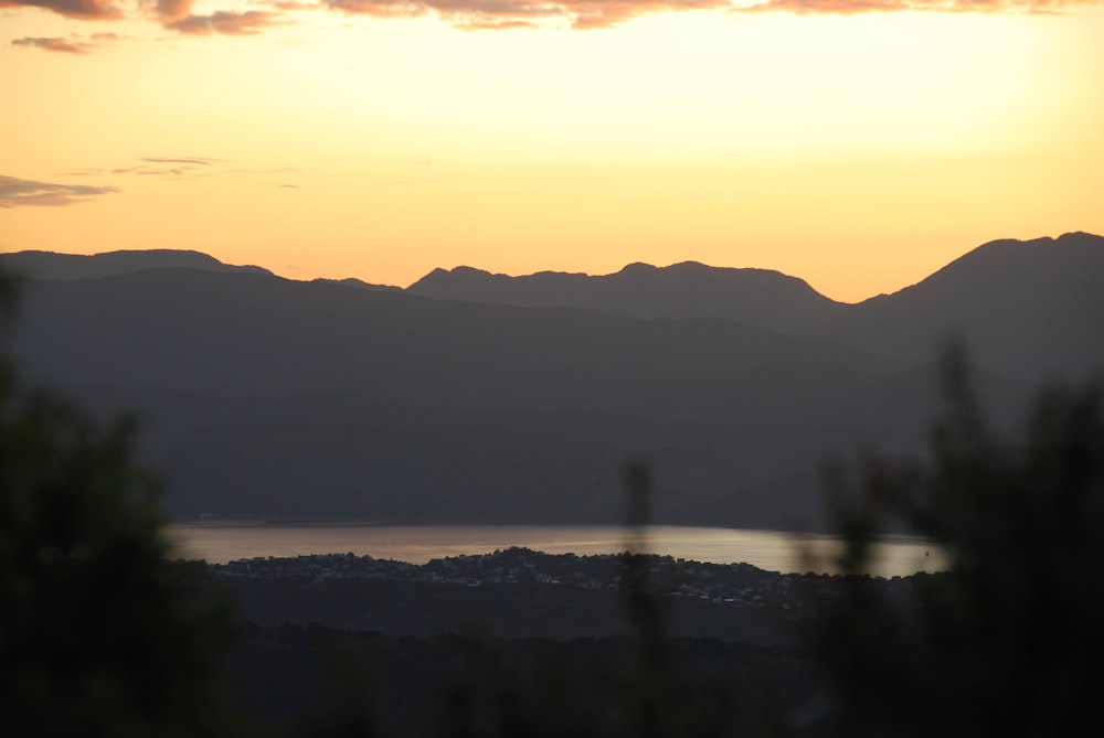 the sun is setting over a mountain range