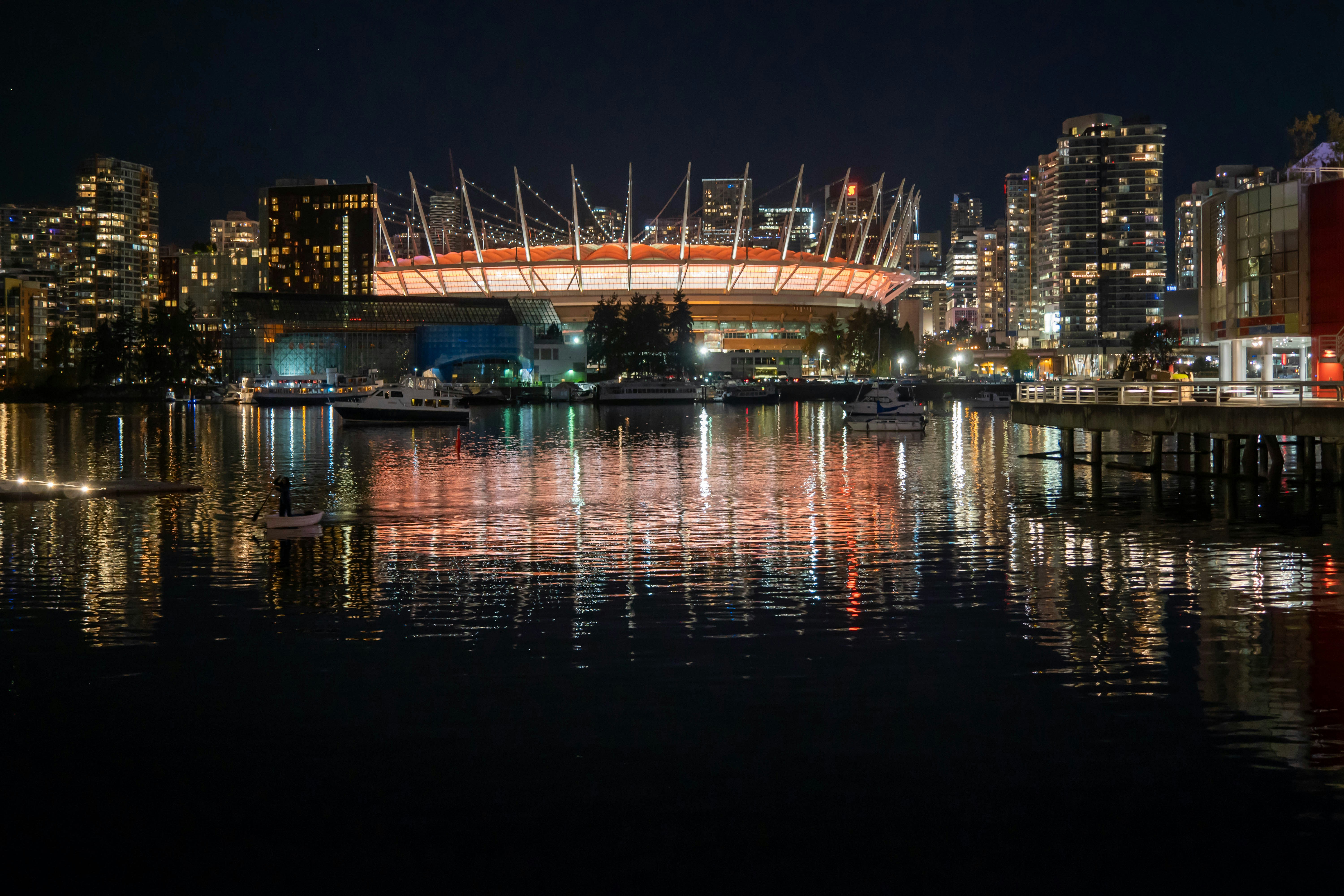 a city skyline at night with a bridge over a body of water