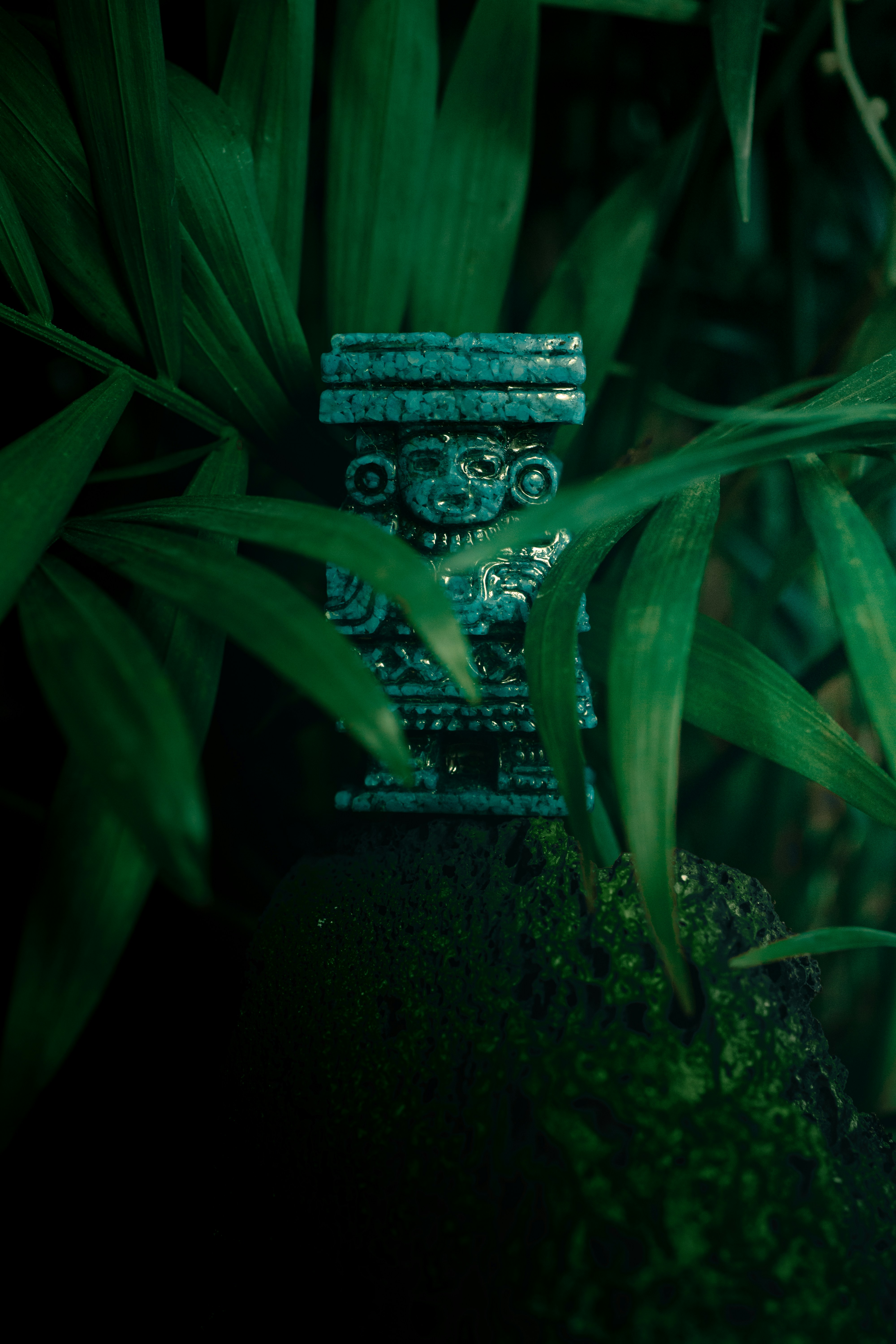 Una estatua verde sentada en la cima de un exuberante campo verde