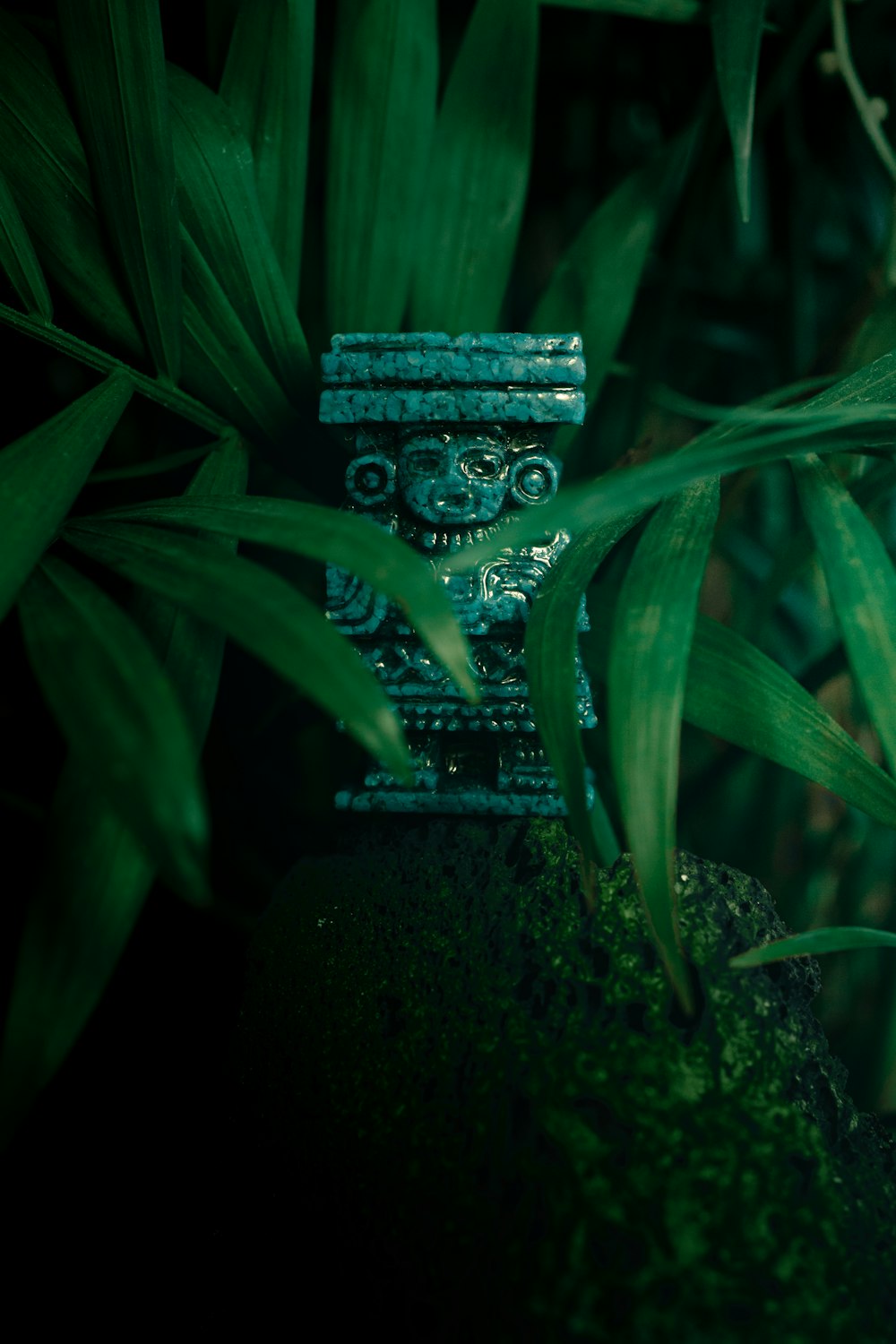 a green statue sitting on top of a lush green field