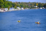 A joyful family kayaking on a calm blue lake.