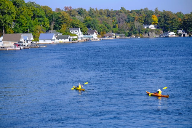 A joyful family kayaking on a calm blue lake.