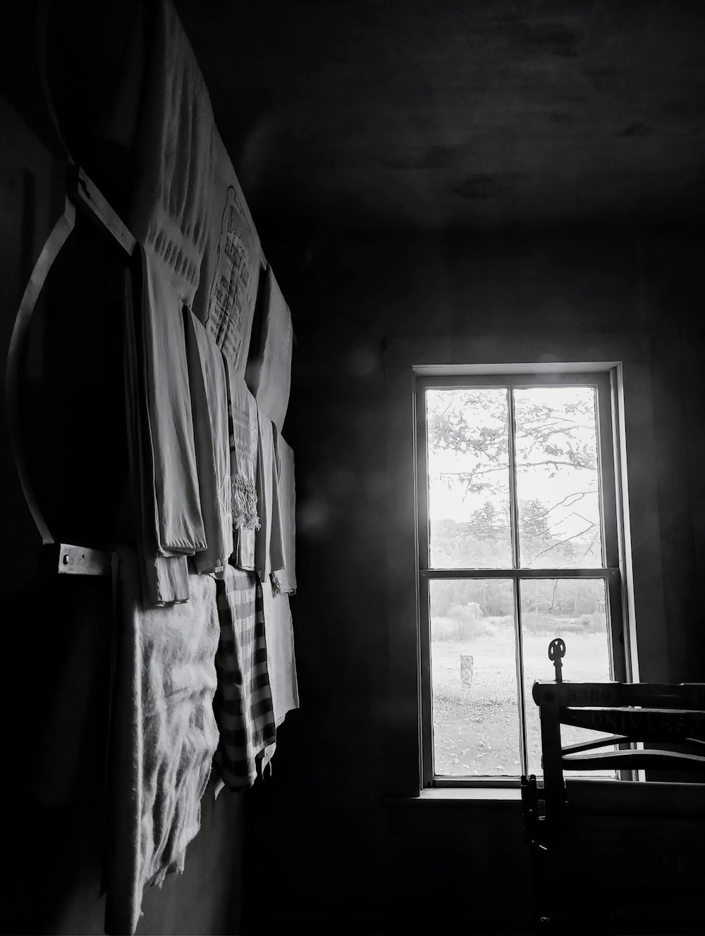 a black and white photo of a window in a dark room