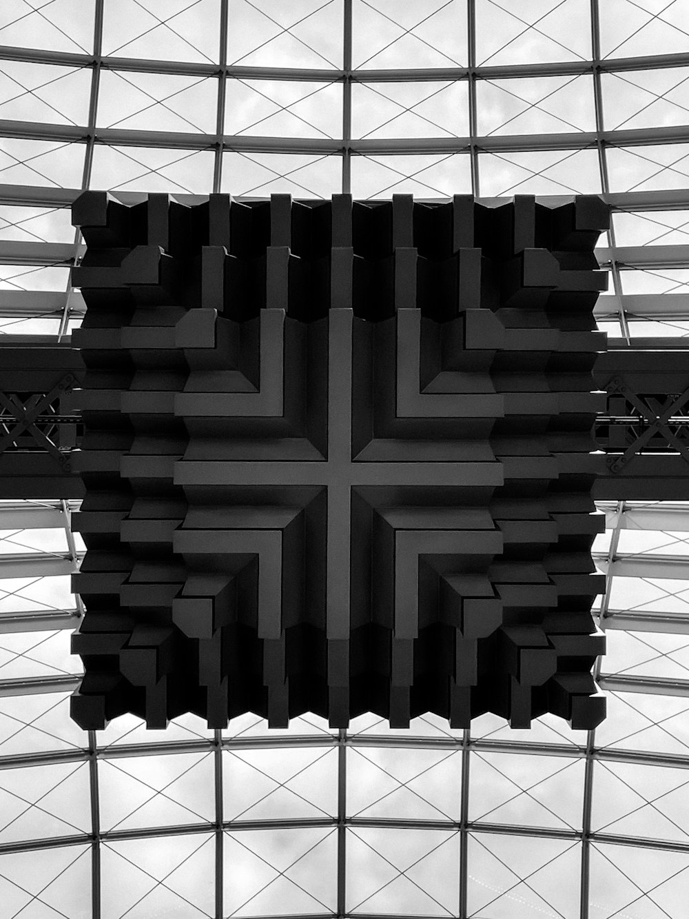 uma foto em preto e branco de uma cruz em um prédio