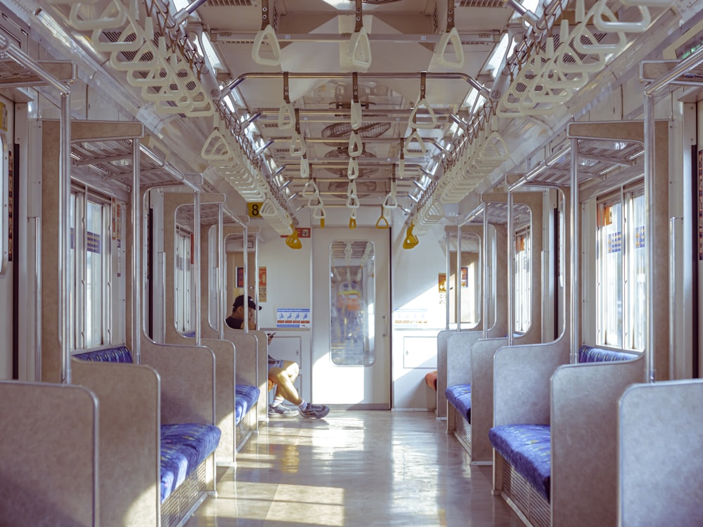 a man sitting on a bench inside of a train