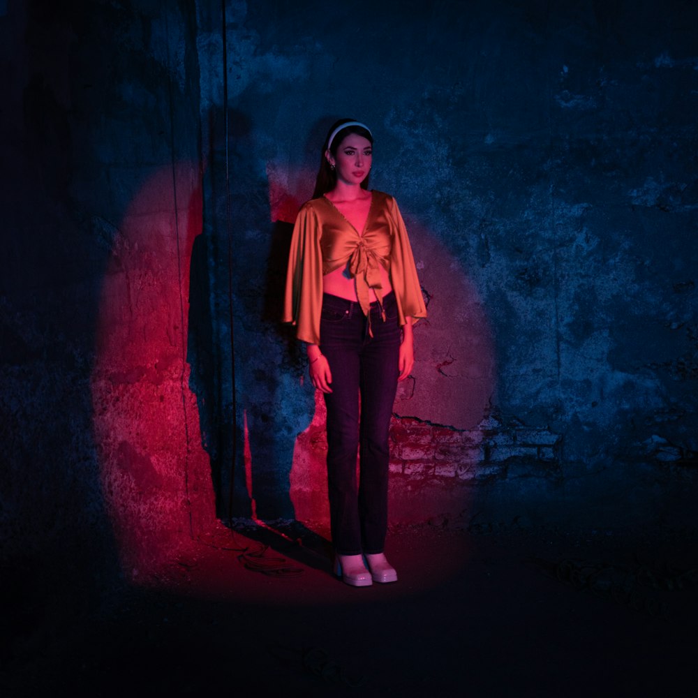 a woman standing in a dark room with a red light
