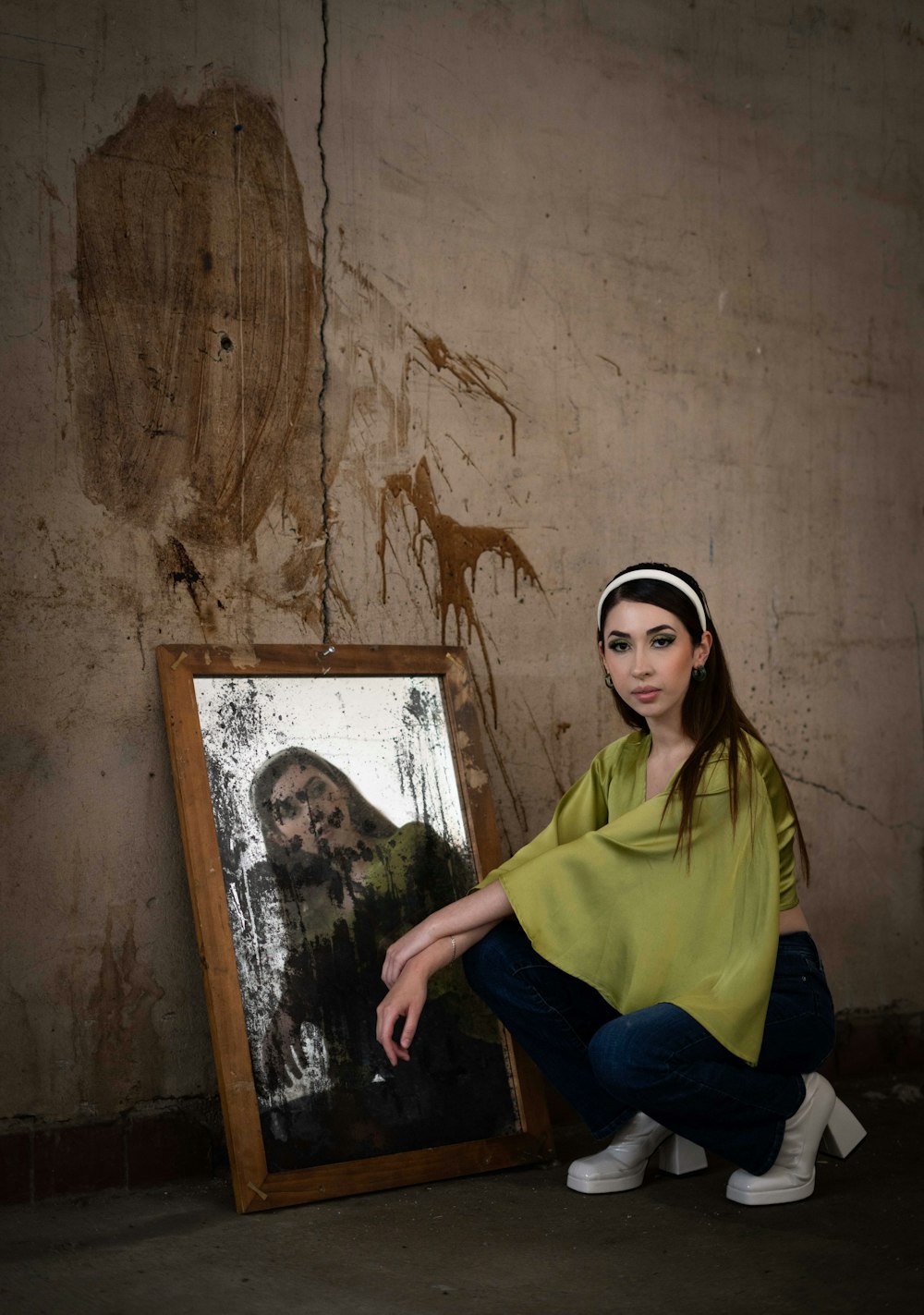 a woman kneeling down next to a painting