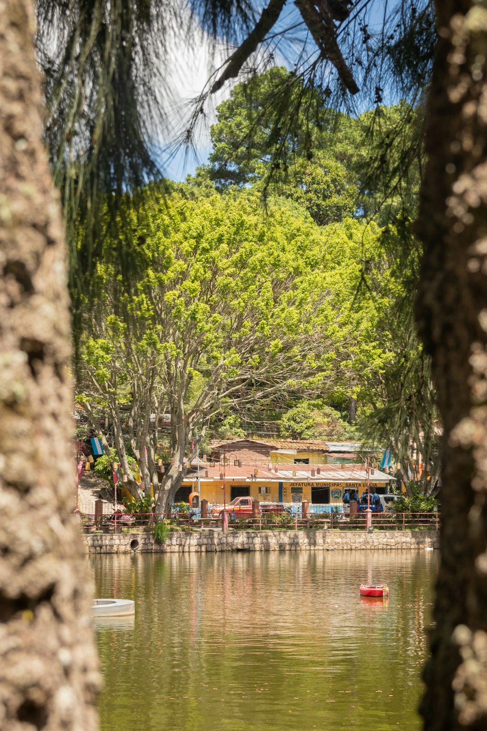 a boat floating on top of a lake next to a forest