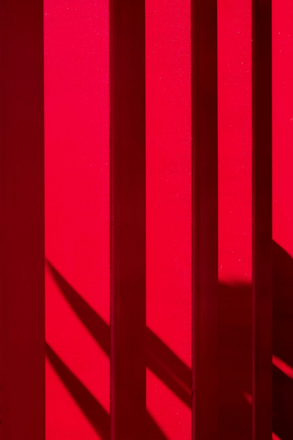 the shadow of a person standing in front of a red wall