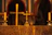 Candles burning softly on a rustic wooden altar with a cross in the background.