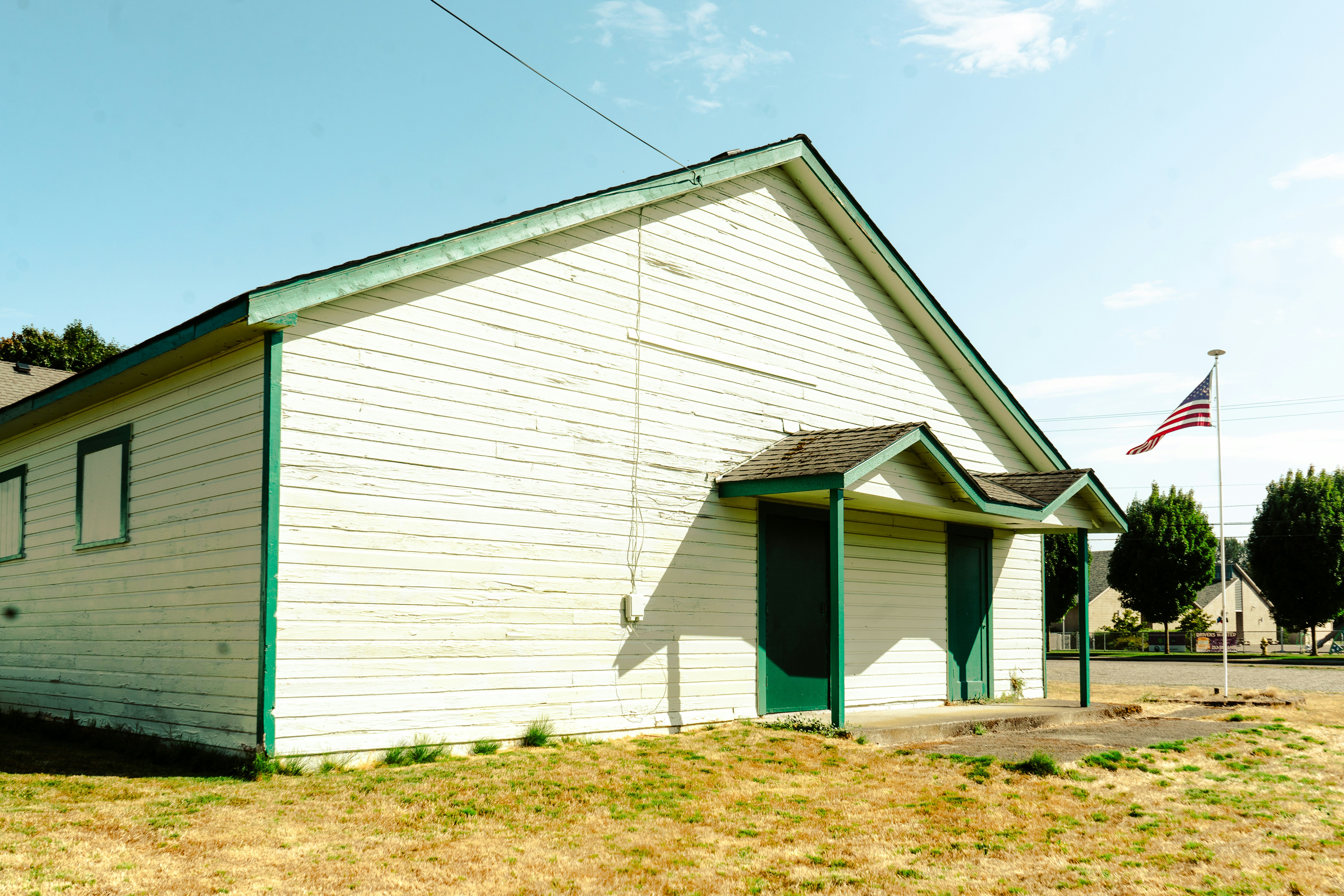 a small white building with a flag on top of it