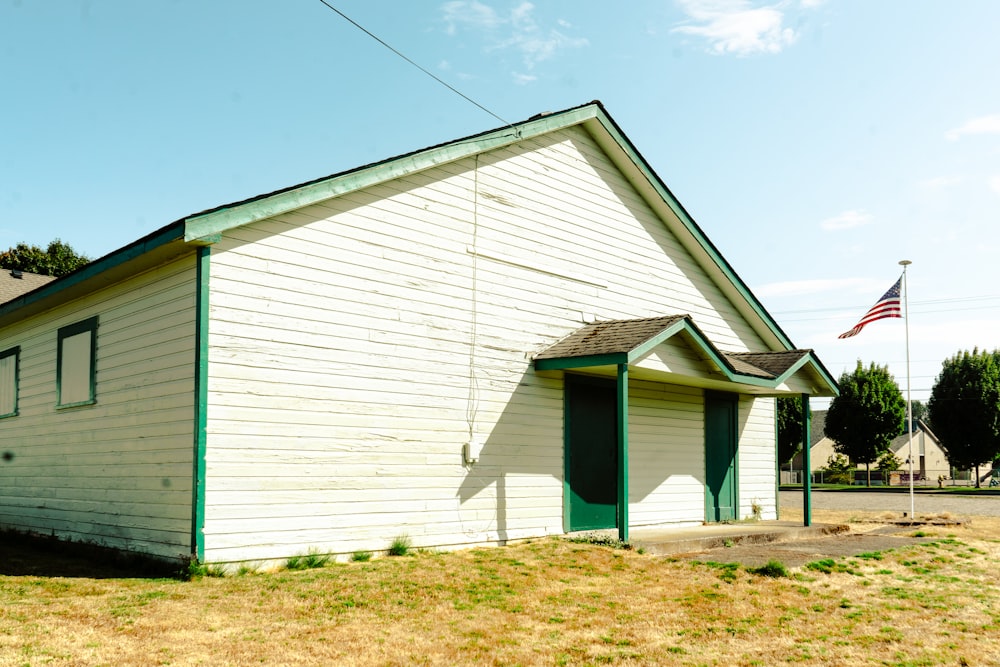 a small white building with a flag on top of it