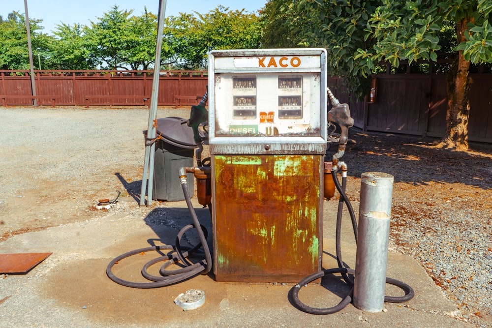 Una vieja bomba de gasolina oxidada sentada al costado de una carretera