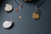 A close-up of alternative jewelry pieces against a dark background.