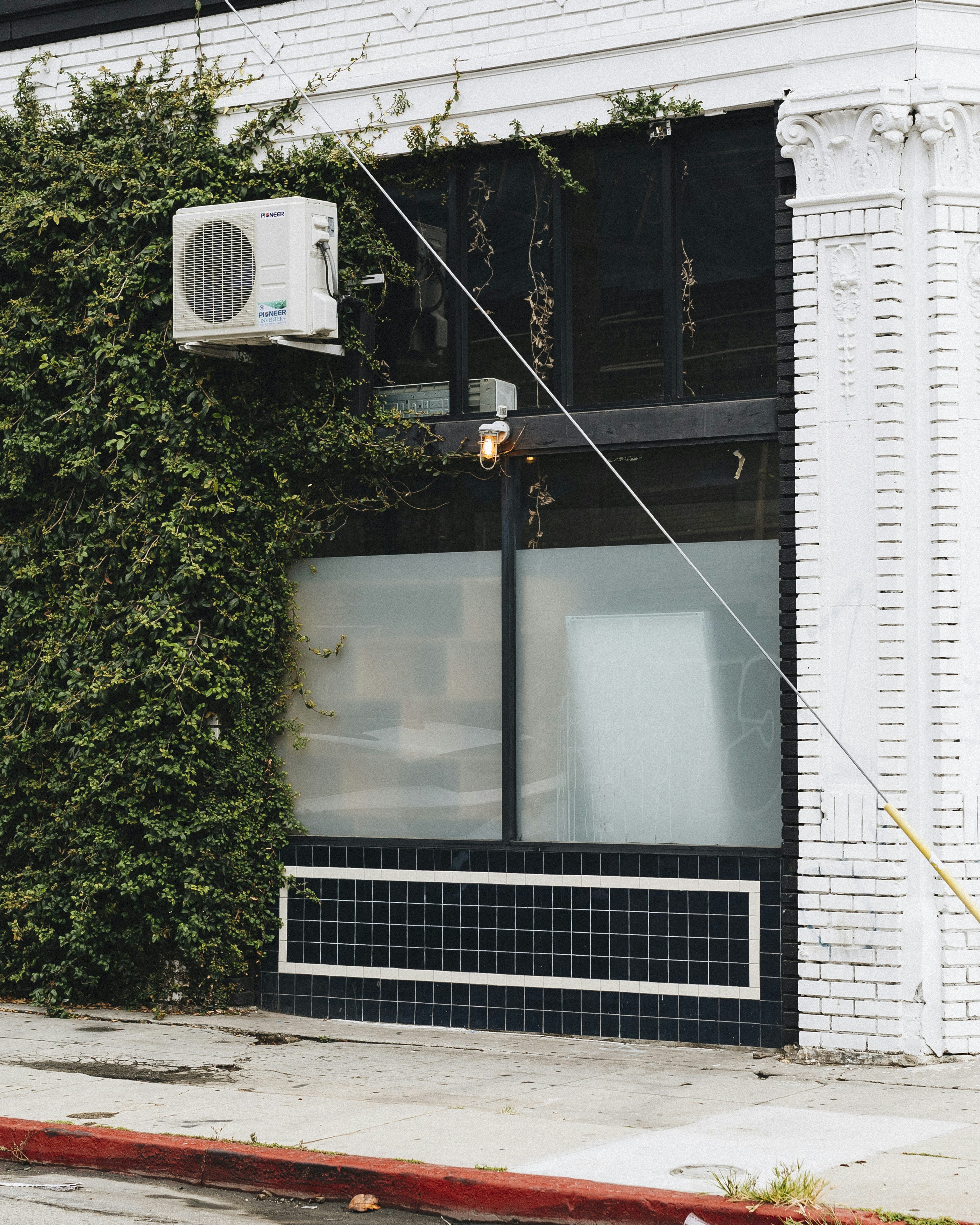 A white air conditioner sitting on the side of a building photo – Free ...