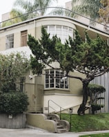 An exterior view of a kost building with greenery and a welcoming entrance.