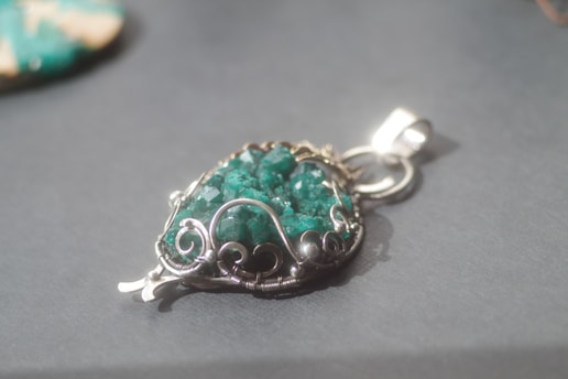 A delicate jade pendant resting on a silk cloth, softly lit to highlight its natural beauty.