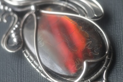 Handcrafted gold pendant encrusted with colorful gems and silver detailing.