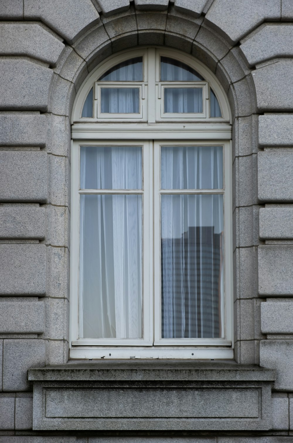 ein Fenster mit einem Vorhang an der Außenseite
