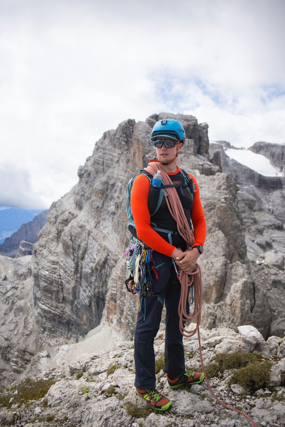 a man standing on top of a mountain holding a rope