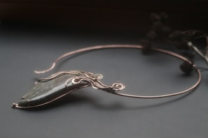 Stylish necklaces with intricate details laid out against natural stone background.