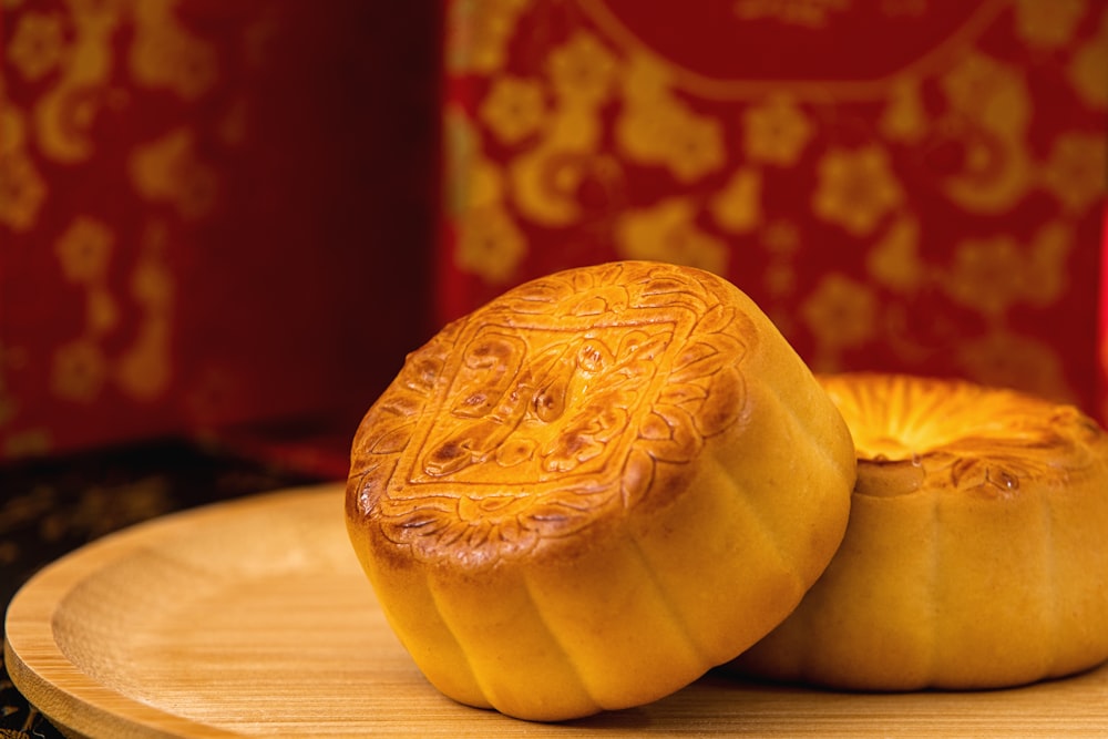 two chinese buns sitting on a plate next to a lit candle