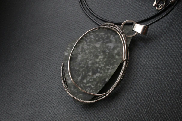 Elegant leather cord necklace with a detailed acrylic pendant inspired by ocean waves