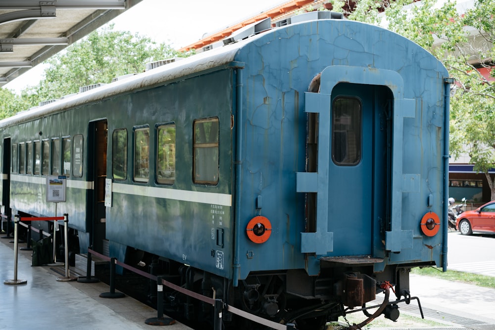 a blue train is parked at a train station