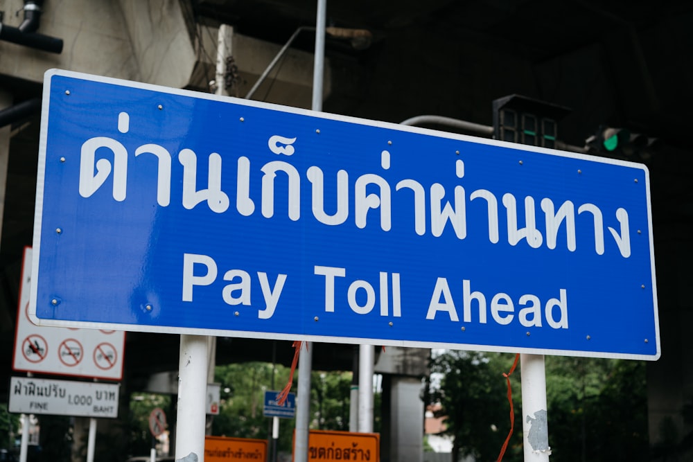a blue sign that says pay toll ahead