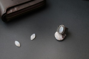 A gold-toned wallet with intricate rhinestone patterns catching the light on a wooden table