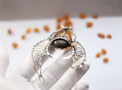 An intricate amulet glowing softly against a black velvet cloth