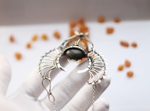 Close-up of elegant hands holding a rare gemstone necklace.