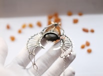 Close-up of hands holding a small amulet surrounded by mystical symbols.