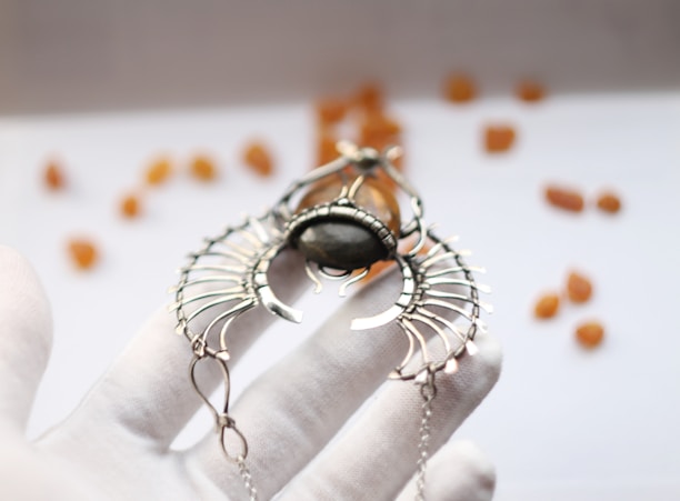 Close-up of a hand holding a smooth, glowing jade pendant.