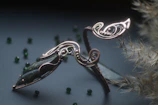 A bracelet with interwoven patterns inspired by gothic tracery, resting on aged parchment.